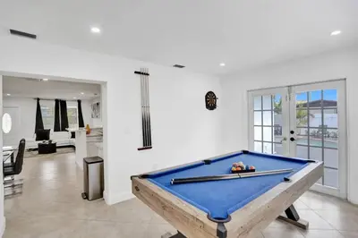 a pool table in the middle of a room at Cozy Fun House 4 2 Aventura Stadium Beach in North Miami Beach