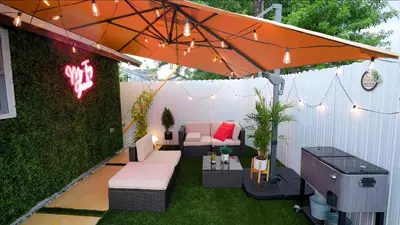 a patio with an umbrella and a couch and a table at Smart Tiny House Garden in Miami Gardens