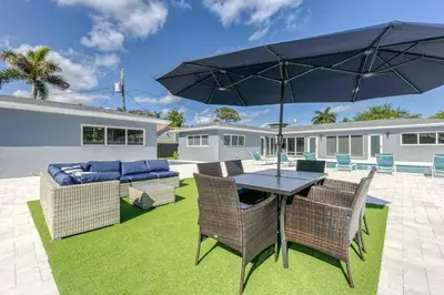 a patio with a table and chairs and an umbrella at Sunshine Manor 2017-2 in Fort Lauderdale