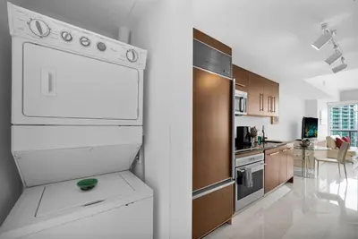a kitchen with a white refrigerator and wooden cabinets at Stylish Studio Icon, W Hotel Waterfront Building in Miami