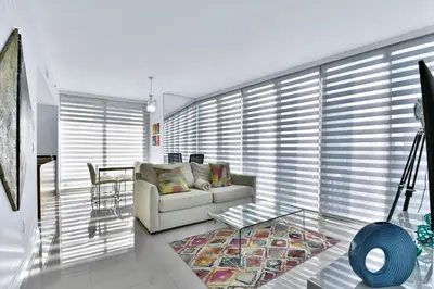 a living room with a couch and a glass table at Amazing 2 Bedroom at Icon in the Heart of Brickell in Miami