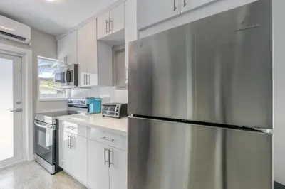 a kitchen with white cabinets and a stainless steel refrigerator at Sunshine Manors 2009 B in Fort Lauderdale