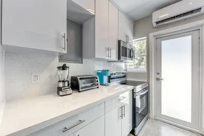 a kitchen with white cabinets and a microwave at Sunshine Manors 2013 A in Fort Lauderdale