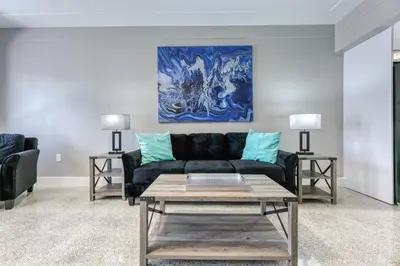 a living room with a black couch and a blue painting at Sunshine Manors 2013 A in Fort Lauderdale