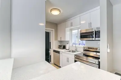 a kitchen with white cabinets and stainless steel appliances at Sunshine Manor 2017-1 in Fort Lauderdale