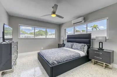 a bedroom with a bed and a tv and windows at Sunshine Manor 2017-1 in Fort Lauderdale