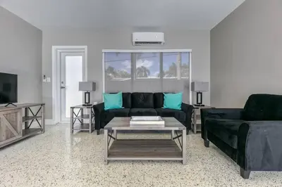 a living room with a black couch and a table at Sunshine Manors 2017-3 in Fort Lauderdale