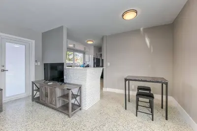 a living room with a table and a television at Sunshine Manors 2025-A in Fort Lauderdale