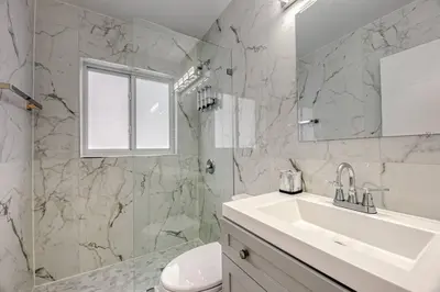 a white bathroom with a sink and a mirror at Sunshine Manors 2025-B in Fort Lauderdale