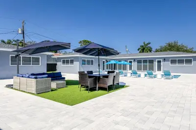 a patio with a table and chairs and umbrellas at Sunshine Manors 2013 B in Fort Lauderdale