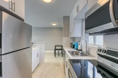 a white kitchen with a sink and a refrigerator at Sunshine Manor 2025-C in Fort Lauderdale