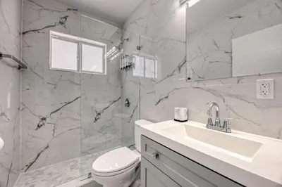 a white bathroom with a toilet and a sink at Sunshine Complex in Fort Lauderdale