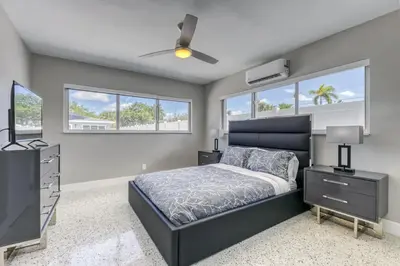 a bedroom with a bed and a tv and windows at Sunshine Complex in Fort Lauderdale
