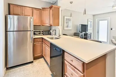 a kitchen with a stainless steel refrigerator and wooden cabinets at Wiltonplex Complex in Fort Lauderdale