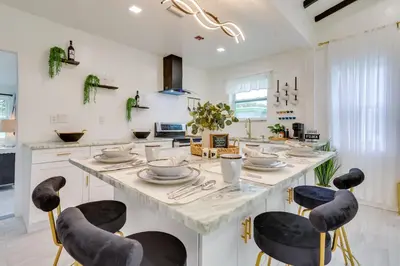 a kitchen with a large island with chairs around it at Stylish Miami Home 2 Mi to Intracoastal Waterway! in Miami