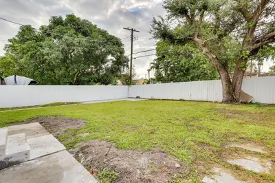 a yard with a white fence and a tree at Stylish Miami Home 2 Mi to Intracoastal Waterway! in Miami