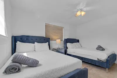 a bedroom with two beds and a blue headboard at Stunning Hollywood Pool Home in Hollywood