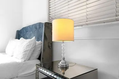 a lamp on a glass table next to a bed at Stunning Hollywood Pool Home in Hollywood