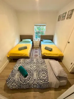 two beds in a small room with a window at Beach vibes 2 bedrooms house in Miami