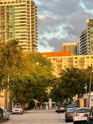 a city street with cars parked in front of tall buildings at Beach vibes 2 bedrooms house in Miami