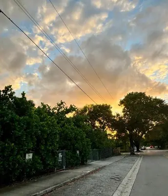 an empty street with trees and a cloudy sky at Beach vibes 2 bedrooms house in Miami