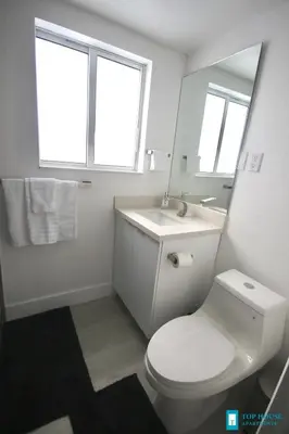 a bathroom with a toilet and a sink and a mirror at 251 Airport/Top House Apartments in Miami