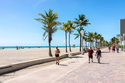 a group of people walking along the beach at 5BD House - Pool+BBQ+King beds - 3 min to beach in Hollywood
