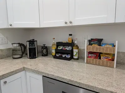 a kitchen with white cabinets and a counter top at Mango Haus Near Beach, Cruise Port & Stadium in Fort Lauderdale