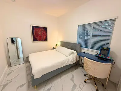 a bedroom with a bed and a desk and a window at Mango Haus Near Beach, Cruise Port & Stadium in Fort Lauderdale