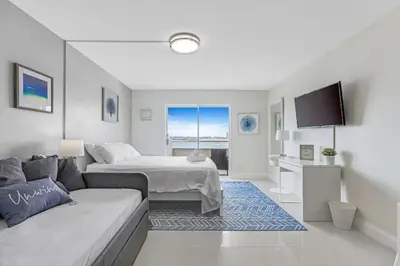 a living room with a couch and a bed at Waterfront Studio Condo in the Heart of Miami - Skyline & Bay Views in Miami Beach