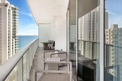 a balcony with chairs and a view of the ocean at Ocean View Balcony with Pool Gym Access in Hallandale Beach