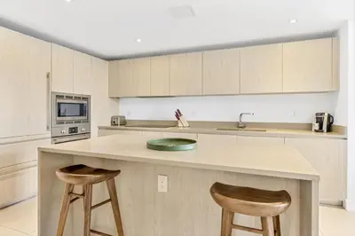a kitchen with two bar stools and a counter top at Ocean View Balcony with Pool Gym Access in Hallandale Beach