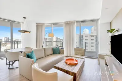 a living room with a couch and a table at Ocean View Balcony with Pool Gym Access in Hallandale Beach