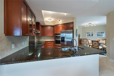 a kitchen with wooden cabinets and a stainless steel refrigerator at 2/2 Boutique Condo in Ft. Lauderdale in Fort Lauderdale