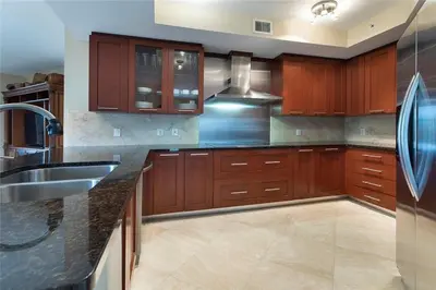 a large kitchen with wooden cabinets and a sink at 2/2 Boutique Condo in Ft. Lauderdale in Fort Lauderdale