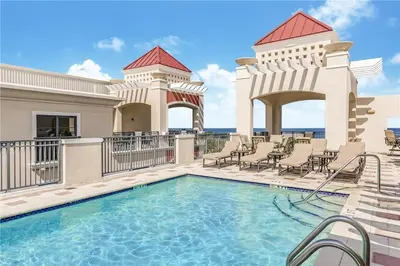 a swimming pool at a resort with chairs and a building at 2/2 Boutique Condo in Ft. Lauderdale in Fort Lauderdale