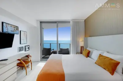 a bedroom with a bed and a tv and a window at 18th Floor Ocean Views Pool Beach Fitness in Hallandale Beach