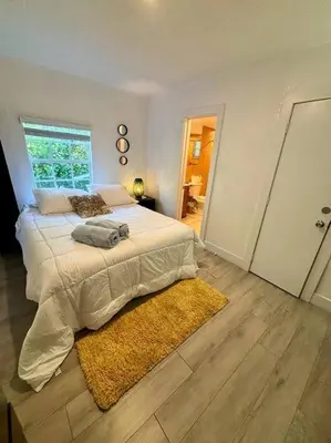 a bedroom with a large bed and a rug at Quiet & Centrally located House - PRIVATE PARKING, LAUNDRY AND STORAGE FOR LUGGAGE in Miami