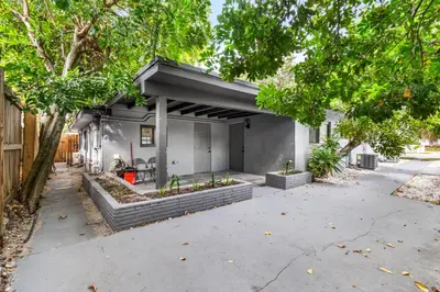 a house with a garage with trees and a driveway at Sun Getaway Rentals in Fort Lauderdale