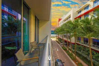 a balcony of a hotel with chairs and palm trees at Amazing Pool - Hot Tub - Hollywood Beach Haven in Hollywood