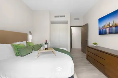 a bedroom with a white bed with a table on it at Amazing Pool - Hot Tub - Hollywood Beach Haven in Hollywood