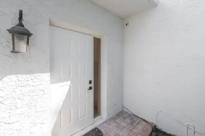 a white door in a white wall with a lamp at Villa at St James Unit A Luxury Pool Villa, Pet Friendly in Miami