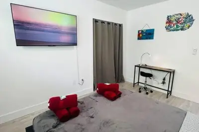 a living room with red chairs and a flat screen tv at Huge 1 bed newly renovated free parking in Miami