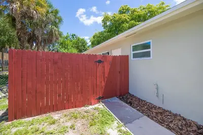 a red fence in front of a house at Boho 6, studio Near Air-Cruise Port & Beach in Fort Lauderdale