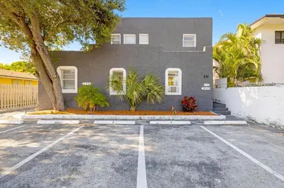 aphalt parking lot in front of a gray house at Azure - Mins to Las Olas & Beach in Fort Lauderdale