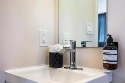 a bottle of soap sitting on a sink in a bathroom at Azure - Mins to Las Olas & Beach in Fort Lauderdale