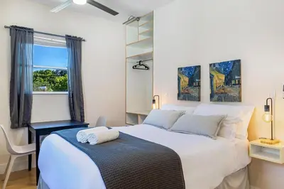 a bedroom with a large white bed and a window at Azure - Mins to Las Olas & Beach in Fort Lauderdale