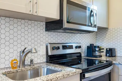 a kitchen with a sink and a microwave at Azure - Mins to Las Olas & Beach in Fort Lauderdale