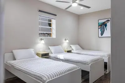 two beds in a white room with a ceiling fan at Lauderdale Bliss - Mins to Las Olas & Beach in Fort Lauderdale