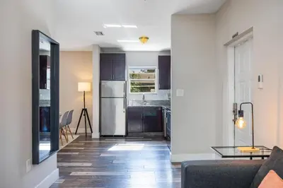 a living room with a couch and a kitchen at Lauderdale Bliss - Mins to Las Olas & Beach in Fort Lauderdale
